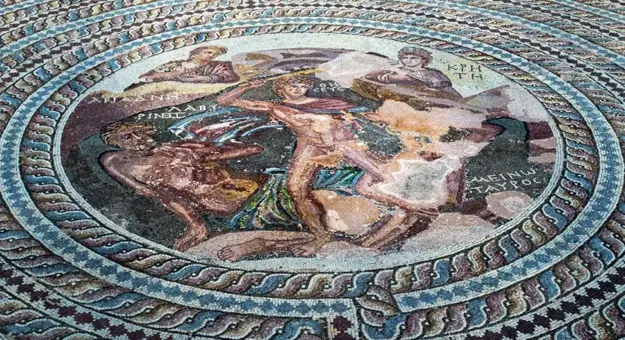 Close up of a circular painting, surrounded by a patterned mosaic